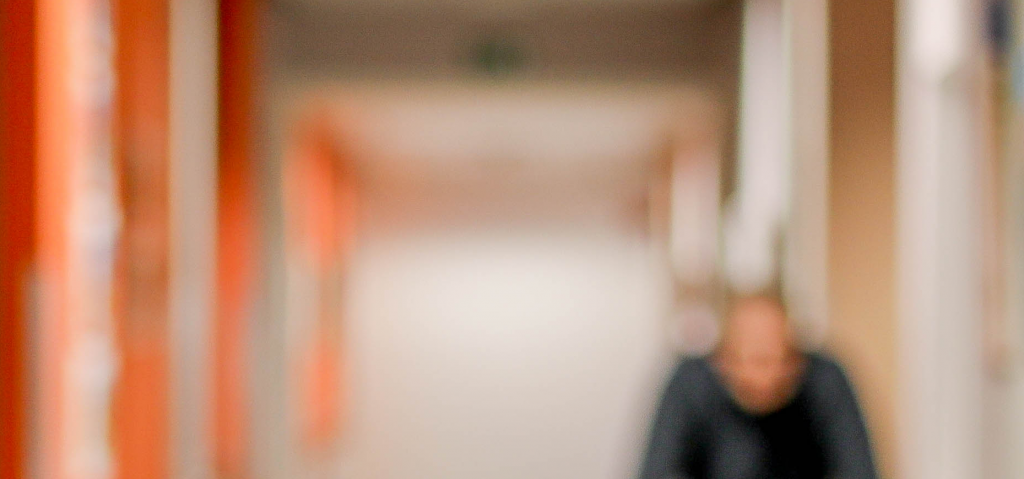 Blurred image of a hallway in nursing home with a silhouet of an older person walking