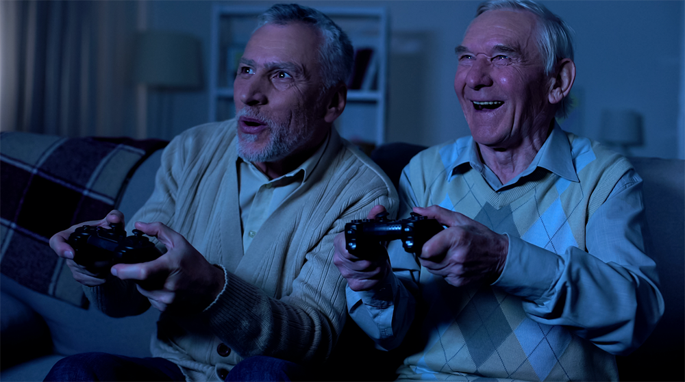 Two older men gaming with PlayStation controllers