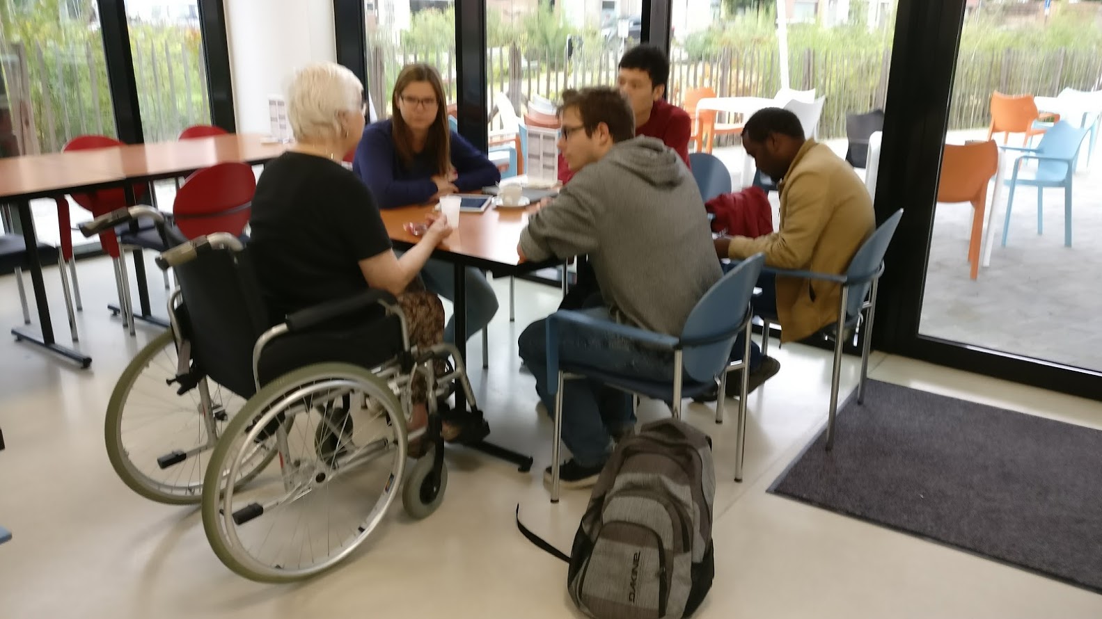 Group of designers and an older adult in a wheelchair codesigning